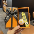 Détail du porte-clés football avec sangle jaune dans son coffret cadeau élégant - Football Jaune Avec Boîte Cadeau Orange