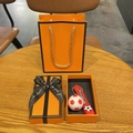 Détail d'un porte-clés football rouge et blanc avec son coffret cadeau orange élégant - Football Rouge Avec Boîte et Sac Cadeau