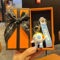 Close-up of a cartoon soccer keychain with headphones in a premium orange gift box - Light Blue Headphone Style With Gift Box