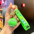 Dettaglio di un portachiavi a pallina da tennis verde con cinturino V SPORT e anello dorato - Tennis (Cinturino Verde)