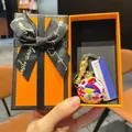 Close-up of World Cup trophy and mini football keychain in a luxury gift box - National Flag Soccer Ball + Gold Trophy + Text Sign + Premium Orange Gift Box