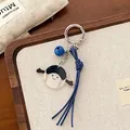 Llavero de béisbol de acrílico con campana azul y correa sobre fondo decorativo - Béisbol