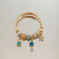 Macro shot of gold charm bracelet with blue star lock and key charms on a mirror - Gold Blue Star Key Rhinestone Bracelet