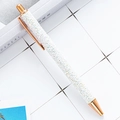 Sparkling white glitter ballpoint pen with rose gold metal trim on a grid paper background - White