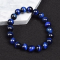 Dunkelblaues Tigerauge-Perlenarmband mit Katzenaugeneffekt auf schwarzem Hintergrund - 6mm / Königsblau