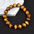 Tiger eye beaded bracelet featuring brown gems with cat eye effect on marble background - Yellow