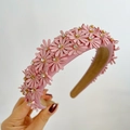 Detailed view of handmade pink 3D fabric flowers with sparkling rhinestone centers on headband - Pink