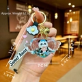 Detail showing cartoon panda liquid sand keychain with Sweet Heart strap and gold bell - Heart Wings Snow Panda