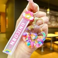 Detail of unicorn donut keychain with pink silicone strap and colorful beads inside - Glow-in-the-dark Rainbow Candy Beans [new Sunflower]