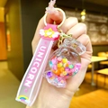 Detail of a pink unicorn keychain featuring a candy-shaped bottle with colorful beads - Glow-in-the-dark Rainbow Candy Beans [round Candy]