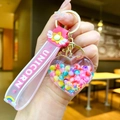 Close-up of heart-shaped keychain with colorful beads and unicorn pink wristband - Glow-in-the-dark Rainbow Candy Beans [heart]