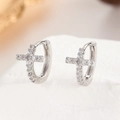 Macro shot of silver cross hoop earrings with sparkling cubic zirconia pavé detailing - 13