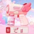 Pink angel wings bubble gun toy with refill bottle on a dreamy pastel sky background - Angel Pink Bubble Machine