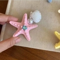 Pink starfish hair claw clip with blue rhinestone and pearl detail held in hand - 5779 Rhinestone Starfish Hair Clip-Pink Starfish