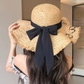 Detail of summer straw hat with large black bow and frayed edge texture on the brim - Khaki Letter Large Bow (D-509)