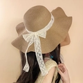 Detailed texture of straw sun hat featuring a large white lace bow and wide wavy brim - Khaki Leaf Label Straw Hat (D-579)