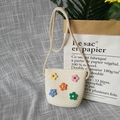 Detailed close-up of handmade straw kids purse with colorful floral plastic decorations - Soft Flower - Cream