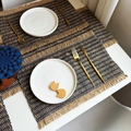 Detailed macro view of woven paper rope placemats with fringe edge in navy blue and natural tan - Jute Fringe Mixed Blue