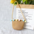Detailed view of straw crossbody bag for kids with colorful pom-poms and woven strap - Lace Color Balls - Khaki