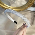 Detailed view of handmade beaded crystal headband with clear faceted stones on white fabric - White