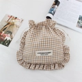 Detail of checkered drawstring bag with ruffled edges and brand label on white surface - Khaki Plaid