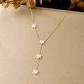 Gros plan d'un collier en Y élégant plaqué or avec de délicats charms en fleurs blanches - Collier en Acier Inoxydable Lariat en Y Fleur Blanche (N4191)