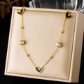Gros plan d'un collier en acier inoxydable doré avec pendentifs cœurs noirs et cristaux. - Collier Or Acier Inoxydable Perle Diamant Cœur Noir (N4197)