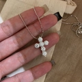 Close-up detail of a sparkling zirconia cross pendant necklace on a silver chain - Cross Pendant Style (HN11513) / Silver