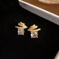 Elegante goldene Spiral-Ohrstecker mit funkelnden Zirkonia-Steinen im Meteor-Design - Gold