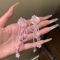 Close-up view of elegant pink flower tassel beaded earrings being held in a hand for detail - Floral Tassel Style (HE32046) / Pink