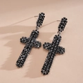 Détail de boucles d'oreilles en forme de croix serties de strass noirs élégants - Métal canon