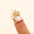 Macro detail of a gold starfish nail ring with sparkling cubic zirconia on a finger - Starfish Style (4125) / KC Gold