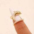 Detailed macro shot of a golden dolphin fingernail ring adorned with cubic zirconia stones - Dolphin Style (5921) / KC Gold