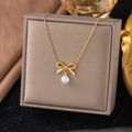 Elegante goldene Schleifenkette mit runder weißer Perle auf einer Schmuckschatulle - 【H351】Schleife Perle Halskette Gold