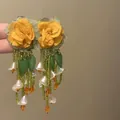 Detailed view of handmade floral earrings with green beaded tassels and leaf accents. - Pastoral Tassel Style (19#)
