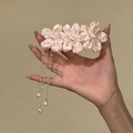 Handheld view of a sweet pink satin flower hair clip with elegant bead tassels. - Duckbill Hair Clips / Pink
