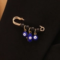 Broche imperdible dorado con ojo turco azul y dijes de la mano de Fátima y perlas - Oro-Cuentas Negras-Doble Ojo Redondo Mano Azul