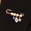 Spilla dorata con malocchio blu, perle bianche e stella rosa su tessuto nero - Oro-Perla Bianca-Occhio Rotondo Stella Rosa Mano Bianca