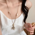 Detail shot of sea snail conch pendant on leather cord worn with a white summer dress - Conch Style / Brown