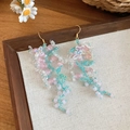 Detailed close-up of handmade pink crystal flower tassel earrings on a vintage wooden tray. - Style 54 (Silver Pin-Eco)
