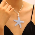 Macro view of the translucent blue starfish pendant on a minimalist white cord necklace. - Blue (6735)