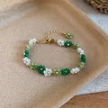 Close-up detail of handmade green and white beaded flower bracelet with gold clasp accents - Bracelet / White-Green