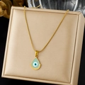 Gros plan d'un collier pendentif oeil de démon doré en forme de goutte sur un présentoir - Collier Pendentif Larme Mauvais Œil Bleu (N4188)