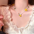 Macro detail showing a sweet beaded necklace with lemon and flower charms on a model - White-Yellow