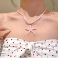 Close-up of a sweet pink resin starfish pendant necklace with a sheer pink ribbon cord - Pink