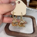 Close-up of elegant gold earrings with large champagne stones and zircon flower detail - Gold Flower / Brown
