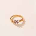 Vista detallada de un anillo de trébol dorado con cuatro circonitas moradas de corazón - Oro Circonita Violeta