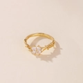 Detalle de un anillo dorado con trébol de cuatro hojas de circón y banda tipo liana. - Dorado Circonita Blanca