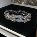 Gros plan d'un élégant bracelet tressé en strass argentés sur un support en velours noir - Style 19 Bracelet