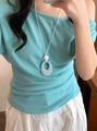 A detailed view of a minimalist blue textured oval pendant necklace with a white cord - Blue